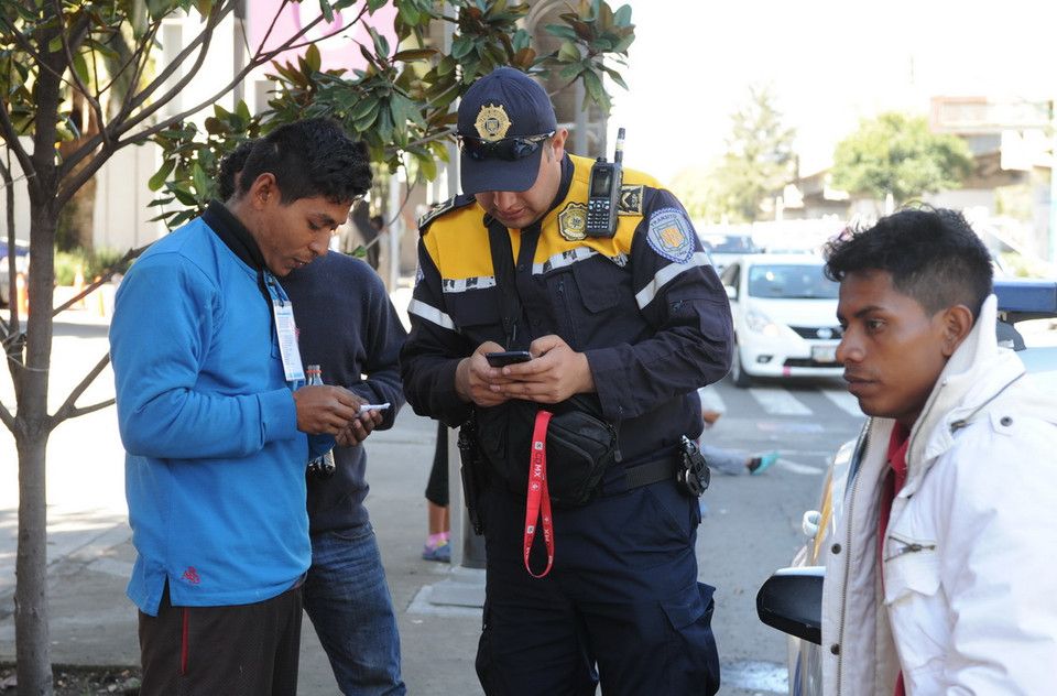 Một cảnh sát giao thông Mexico giúp người di cư liên lạc với gia đình tại quê nhà. (Ảnh: Việt Hùng/Vietnam+)