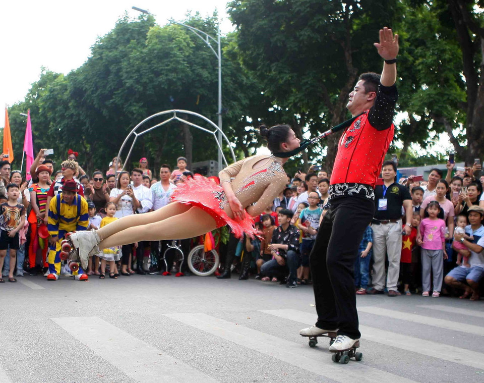 Các nghệ sỹ diễu hành, biểu diễn tại khu vực phố đi bộ Hồ Gươm (Hà Nội). (Ảnh: Thanh Tùng/TTXVN)