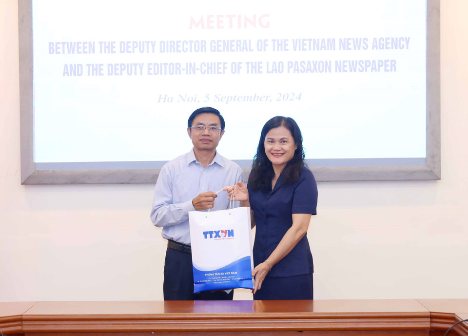 Phó Tổng Giám đốc Thông tấn xã Việt Nam Nguyễn Thị Sự trao quà lưu niệm cho Phó Tổng Biên tập Báo Pasaxon Lào, ông Syvanh Homsayadeth. (Ảnh: Phương Hoa/TTXVN)