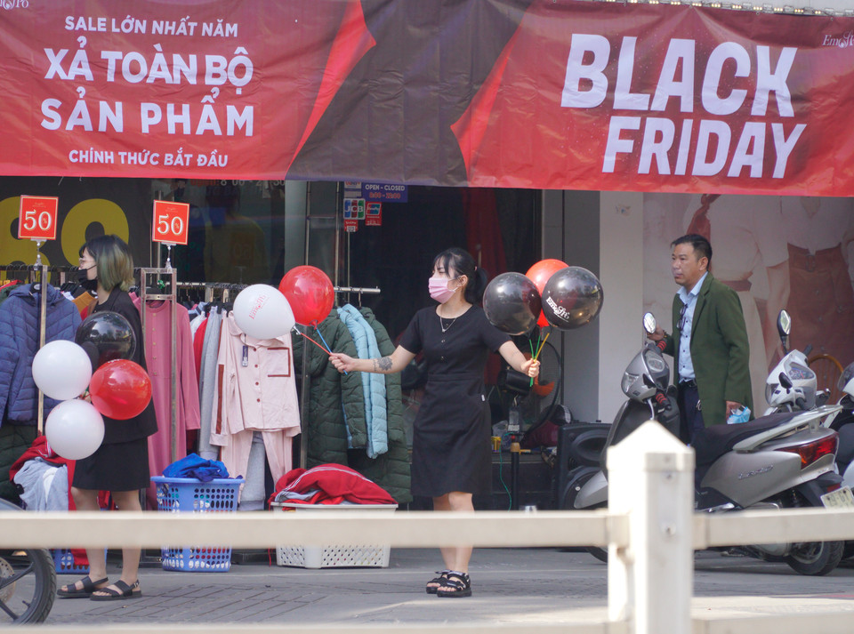 Nhân viên tại một cửa hàng thời trang ra đường hoạt náo ‘kéo’ khách. (Ảnh: Minh Hiếu/Vietnam+)