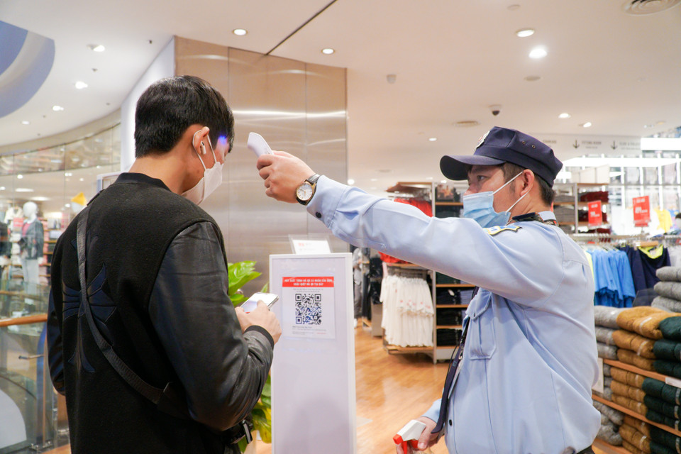 Khách hàng được bảo vệ trung tâm thương mại đo thân nhiệt, khử khuẩn cũng như yêu cầu khai báo y tế trước khi vào bên trong mua sắm. (Ảnh: Minh Hiếu/Vietnam+)