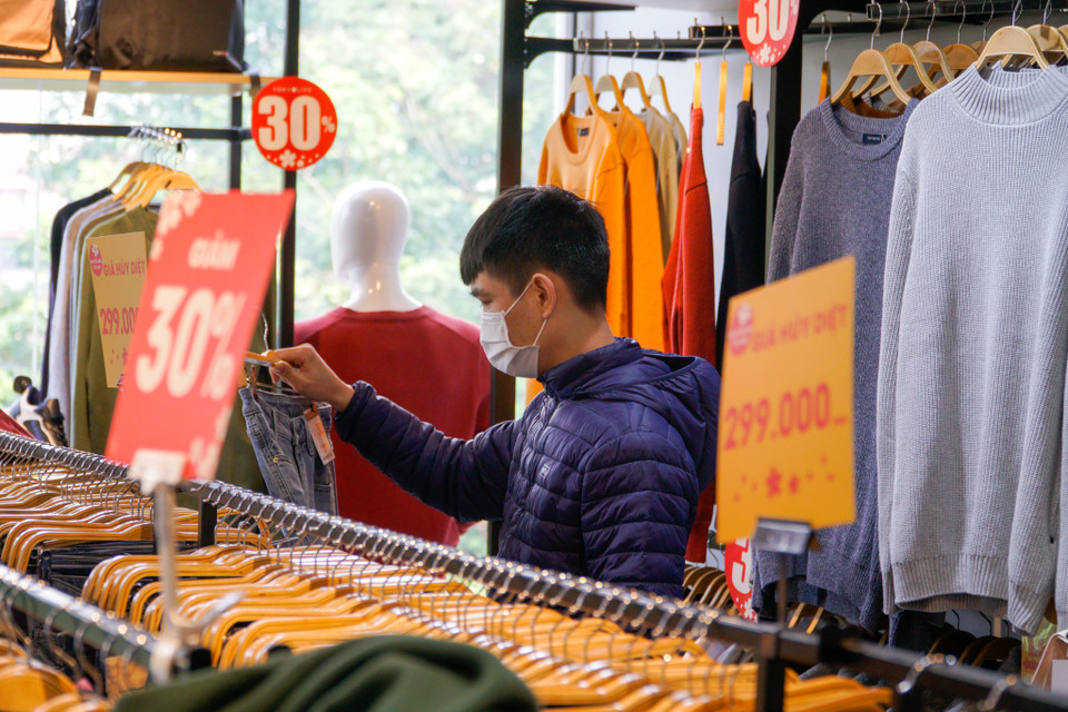 Tuấn Minh, sinh viên một trường đại học cho biết nhân ngày nghỉ em có đến shop quen để mua sắm quần áo, giày thể thao. Cửa hàng này giảm đến 50% rất nhiều mẫu mà chỉ có mỗi mình là khách. Tình cảnh này khác hẳn năm trước khi nhiều người đổ xô đến mua một lúc. (Ảnh: Minh Hiếu/Vietnam+)