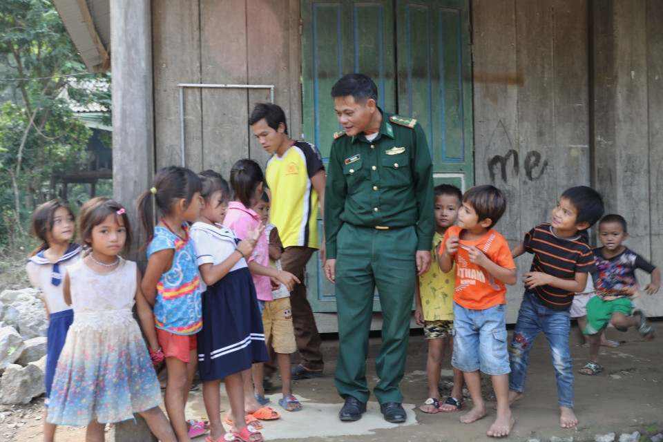 Cán bộ Đồn biên phòng Làng Mô cùng trẻ nhỏ thôn Trung Sơn, xã Trường Sơn, huyện Quảng Ninh (Quảng Bình). (Ảnh: Danh Lam/TTXVN)