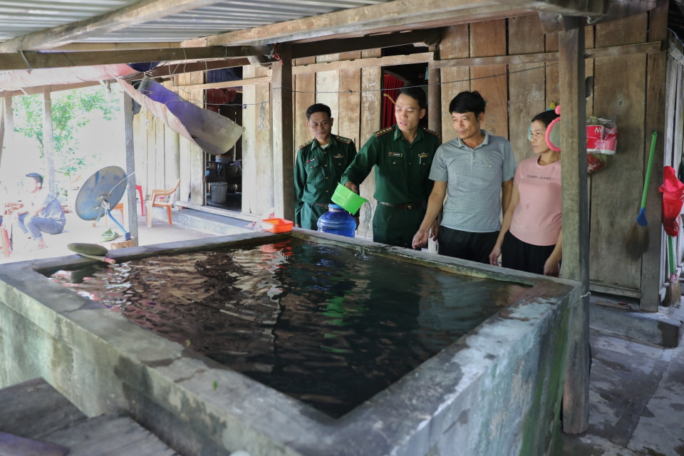 Cán bộ Đồn biên phòng Làng Mô tìm hiểu tình hình sử dụng nước sạch của gia đình anh Trịnh Đức Tiến, thôn Long Sơn, xã Trường Sơn, huyện Quảng Ninh (Quảng Bình) sau khi lũ rút. (Ảnh: Danh Lam/TTXVN)