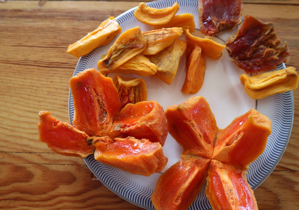 Hồng sấy bằng công nghệ Hàn Quốc có màu vàng, bên trong ruột hồng vẫn vàng đậm, hơi đỏ và mềm dẻo không khác hồng chín cây. (Ảnh: Nguyễn Dũng/TTXVN)