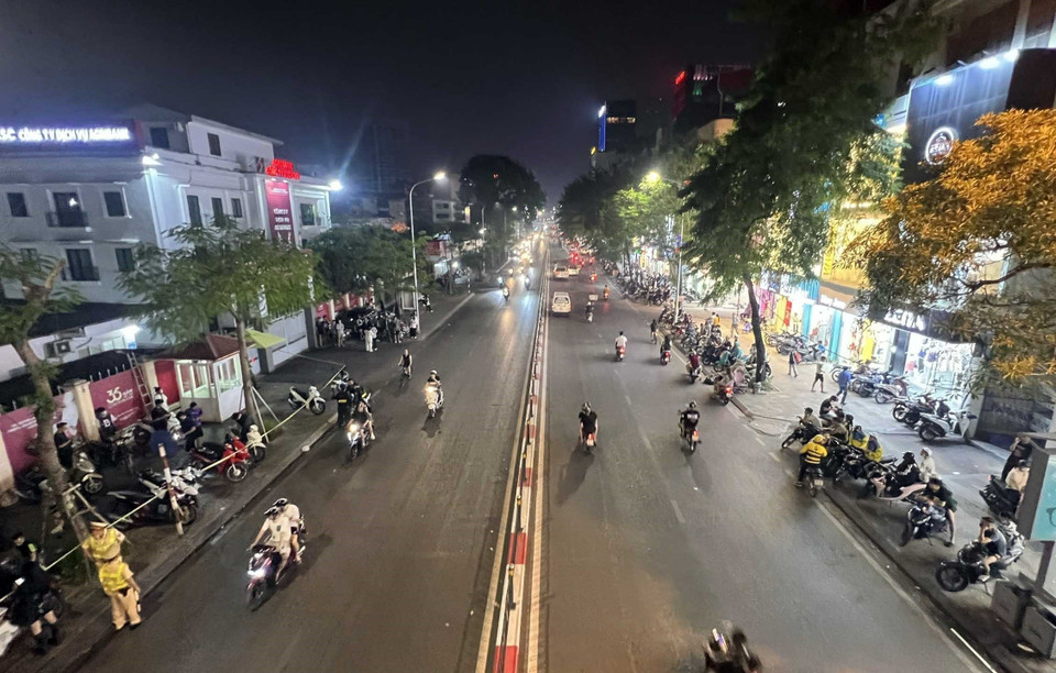 Hàng trăm người tụ tập hai bên đường để quan sát Tổ công tác 141 làm nhiệm vụ, đồng thời sử dụng điện thoại livestream, hò reo cổ vũ khi có một thanh niên nào đó lạng lách, đánh võng qua tổ công tác. (Ảnh: Phạm Kiên/TTXVN)