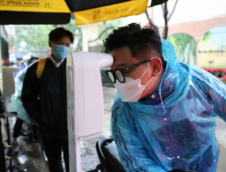 Học sinh đo thân nhiệt trước khi vào lớp. (Ảnh: Thanh Tùng/TTXVN)