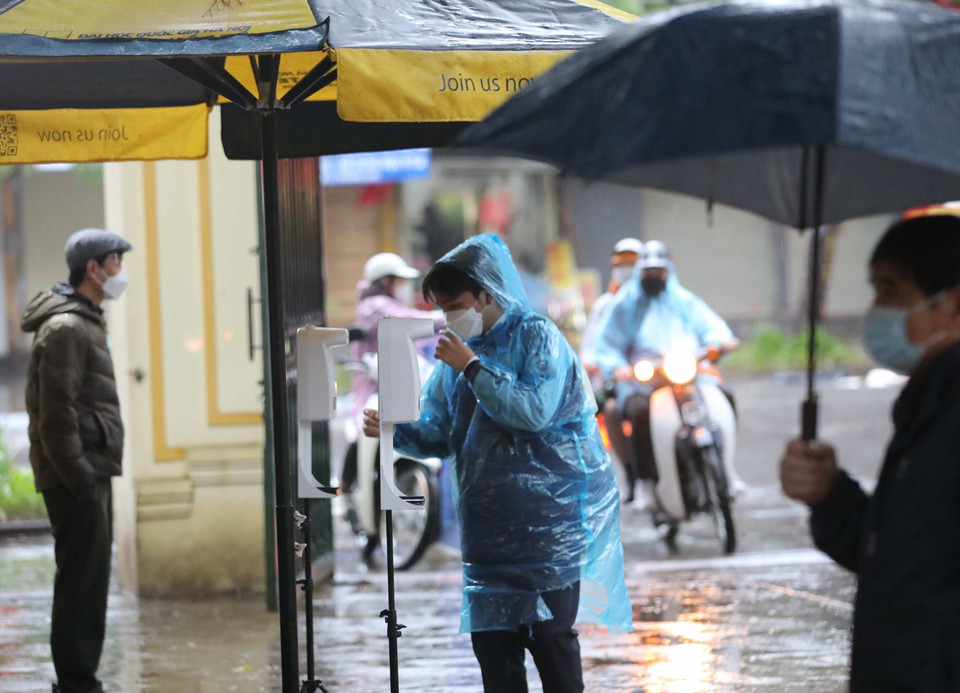 Đo thân nhiệt và sát khuẩn tay là bắt buộc khi tới trường học trực tiếp. (Ảnh: Thanh Tùng/TTXVN)