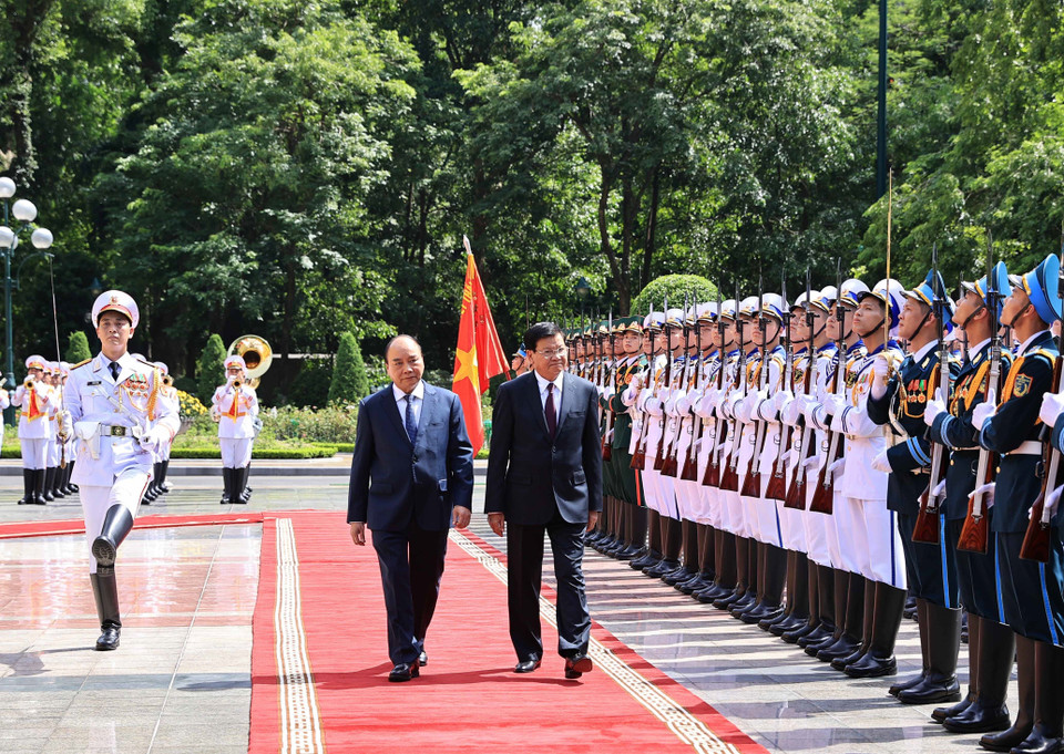 Chủ tịch nước Nguyễn Xuân Phúc và Tổng Bí thư Ban Chấp hành Trung ương Đảng Nhân dân Cách mạng Lào, Chủ tịch nước Cộng hòa Dân chủ Nhân dân Lào Thongloun Sisoulith duyệt Đội danh dự Quân dội nhân dân Việt Nam. (Ảnh: Thống Nhất/TTXVN)