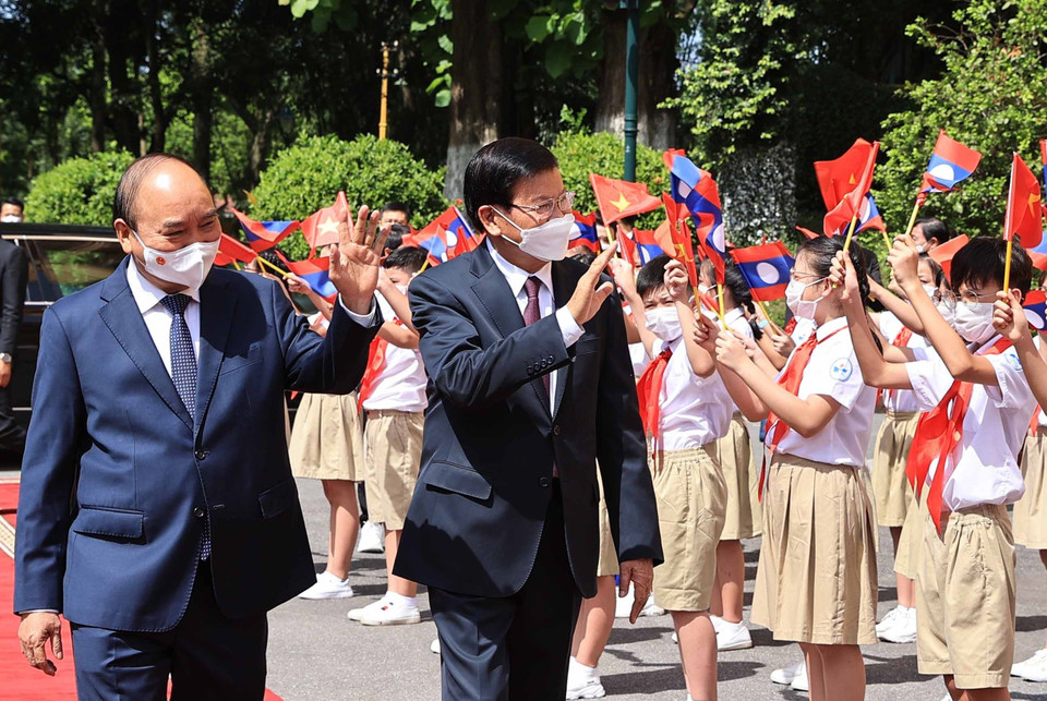 Chủ tịch nước Nguyễn Xuân Phúc và Tổng Bí thư Ban Chấp hành Trung ương Đảng Nhân dân Cách mạng Lào, Chủ tịch nước Cộng hòa Dân chủ Nhân dân Lào Thongloun Sisoulith với thiếu nhi Thủ đô tại lễ đón. (Ảnh: Thống Nhất/TTXVN)