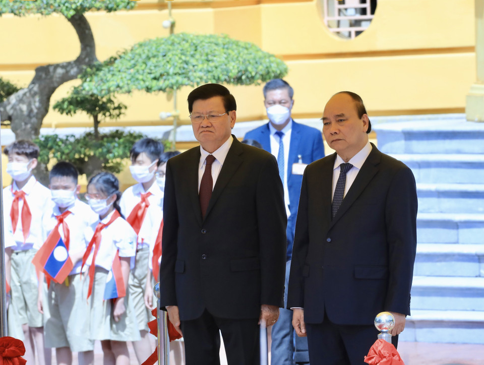 Chủ tịch nước Nguyễn Xuân Phúc và Tổng Bí thư, Chủ tịch nước CHDCND Lào Thongloun Sisoulith nghe Quân nhạc cử Quốc thiều hai nước tại lễ đón. (Ảnh: Lâm Khánh/TTXVN)