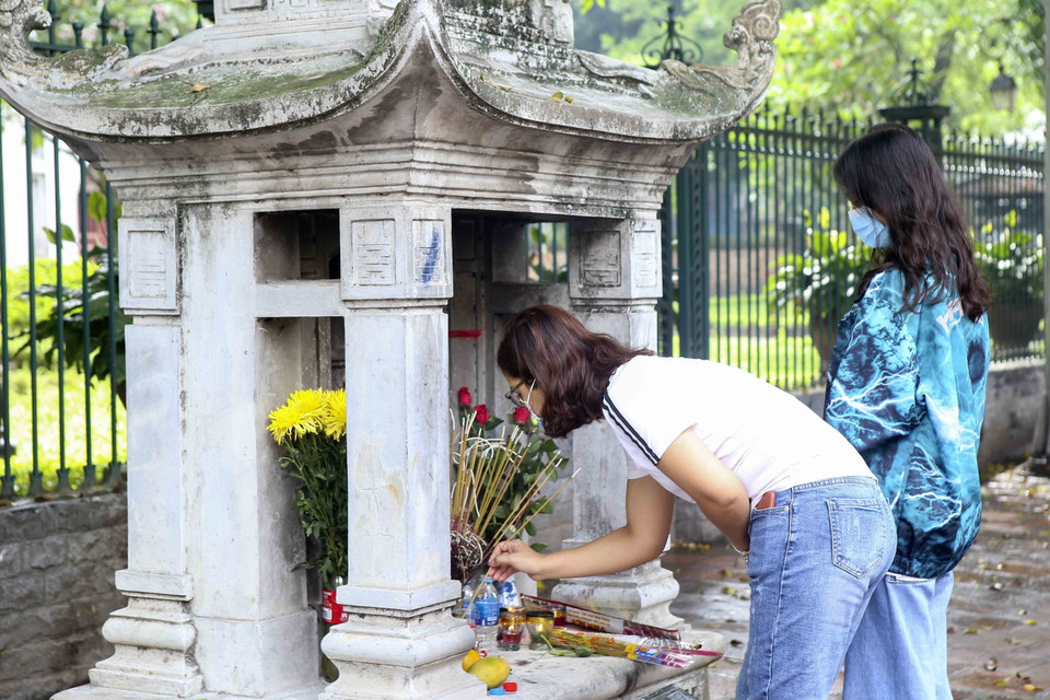 Các sỹ tử thắp hương tại ngôi miếu bên ngoài Văn Miếu-Quốc Tử Giám. (Ảnh: Tuấn Đức/TTXVN)