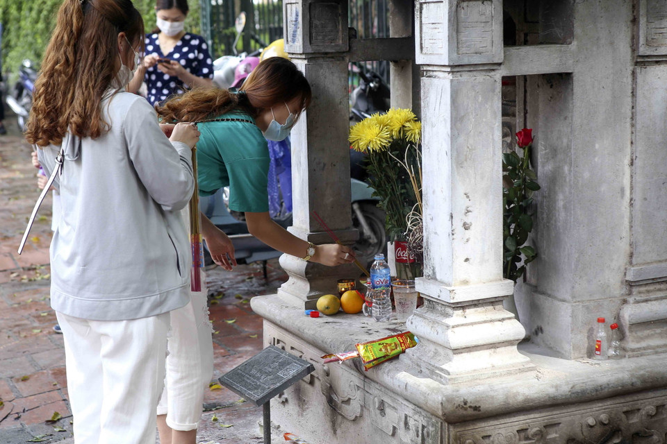 Các sỹ tử thắp hương tại ngôi miếu bên ngoài Văn Miếu-Quốc Tử Giám. (Ảnh: Tuấn Đức/TTXVN)