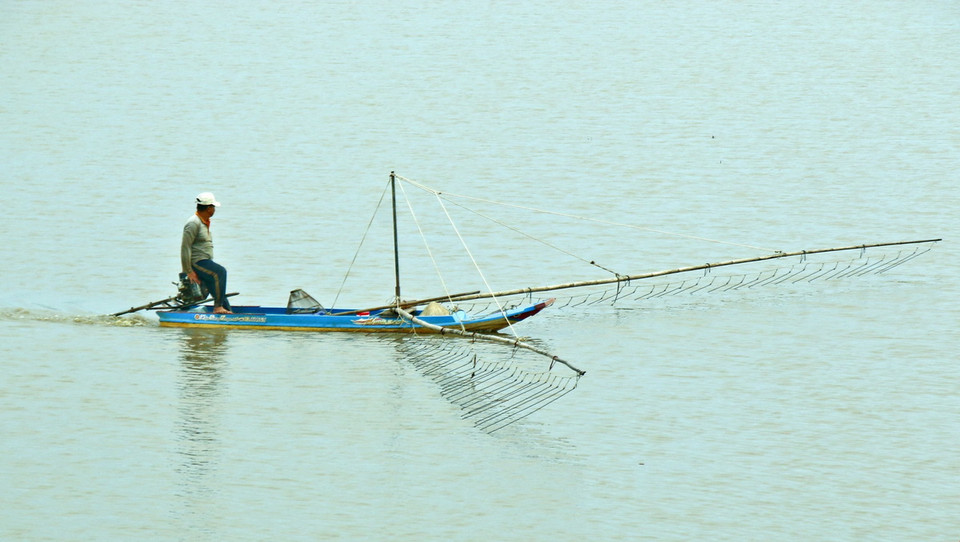 Đẩy côn bắt cá trên những cánh đồng ngập lũ ở Hậu Giang. (Ảnh: Duy Khương/ TTXVN)