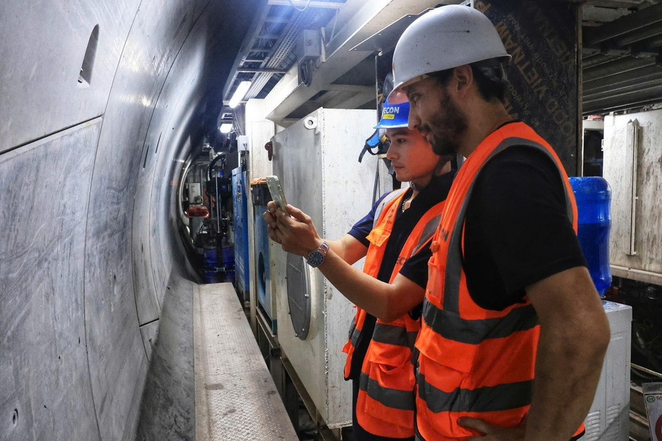 Kỹ sư Việt Nam trao đổi với chuyên gia nước ngoài ngay tại hầm khoan. (Ảnh: Tuấn Anh/TTXVN)