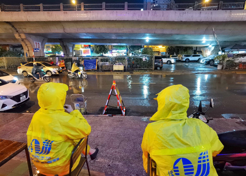 Nhân viên Công ty thoát nước ứng trực trên phố Minh Khai, quận Hai Bà Trưng để xử lý tình huống khi có mưa ngập. (Ảnh: Thanh Tùng/TTXVN)