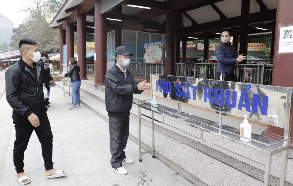 Du khách thực hiện sát khuẩn trước khi vào thăm quan chùa Hương. (Ảnh: Trần Việt/TTXVN)