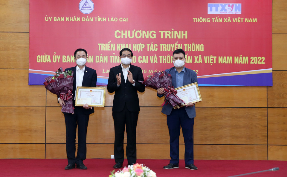 Chủ tịch Ủy ban Nhân dân tỉnh Lào Cai Trịnh Xuân Trường trao tặng kỷ niệm chương Vì sự nghiệp phát triển tỉnh Lào Cai cho hai cán bộ của Thông tấn xã Việt Nam. (Ảnh: Quốc Khánh/TTXVN)