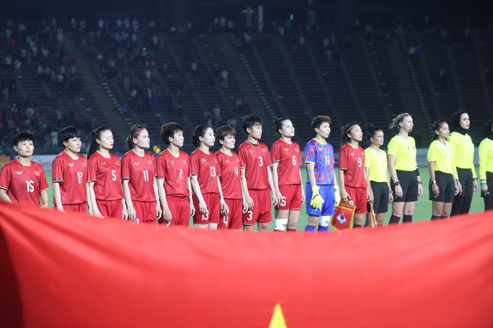 Các tuyển thủ nữ Việt Nam thực hiện nghi thức chào cờ. (Ảnh: Hoàng Linh/TTXVN)
