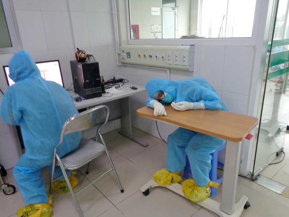 Công việc quá tải gấp vài lần những ngày bình thường. Nhịp sinh hoạt của các y bác sỹ nơi đây thay đổi hoàn toàn từ khi có dịch bệnh xuất hiện. Trong ảnh: Hình ảnh những bác sỹ, nhân viên y tế tranh thủ chợp mắt ngay tại nơi làm việc khiến ai nấy không khỏi nao lòng và thêm trân trọng những công lao đóng góp của họ cho sức khỏe nhân dân. (Ảnh: TTXVN phát)