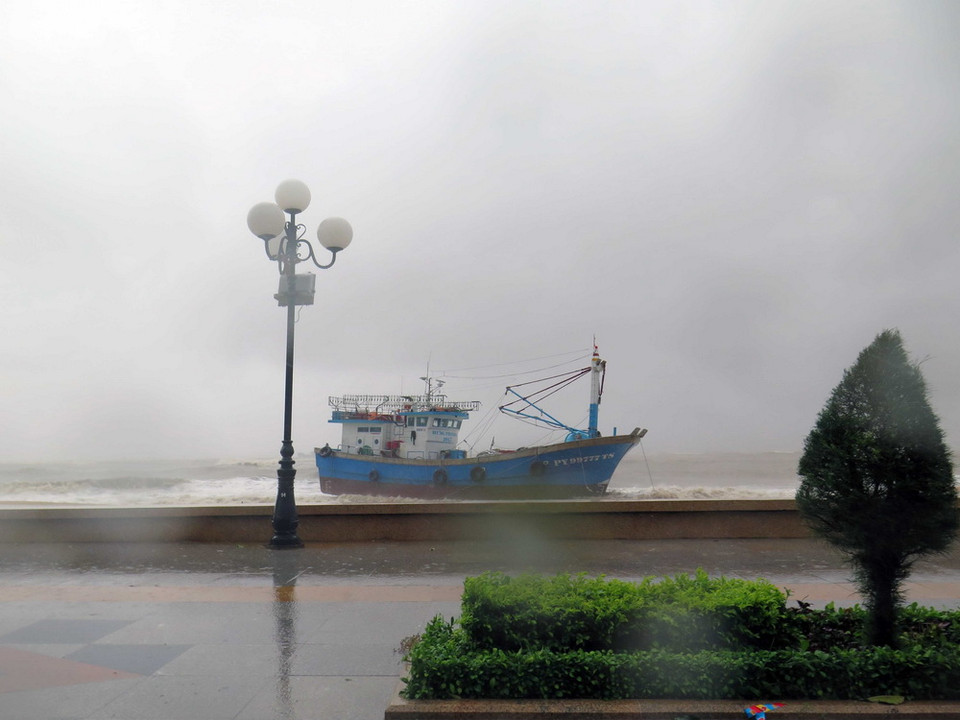 Tàu cá PY99777TS của ngư dân Phú Yên bị sóng đánh dạt vào bờ biển thành phố Quy Nhơn. (Ảnh: Phạm Kha/TTXVN)