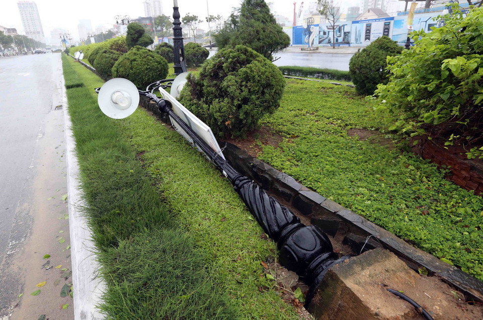  Cột đèn điện chiếu sáng trên đường Pham Văn Đồng bị gió quật ngã, đổ hư hỏng. (Ảnh: Trần Lê Lâm/TTXVN)