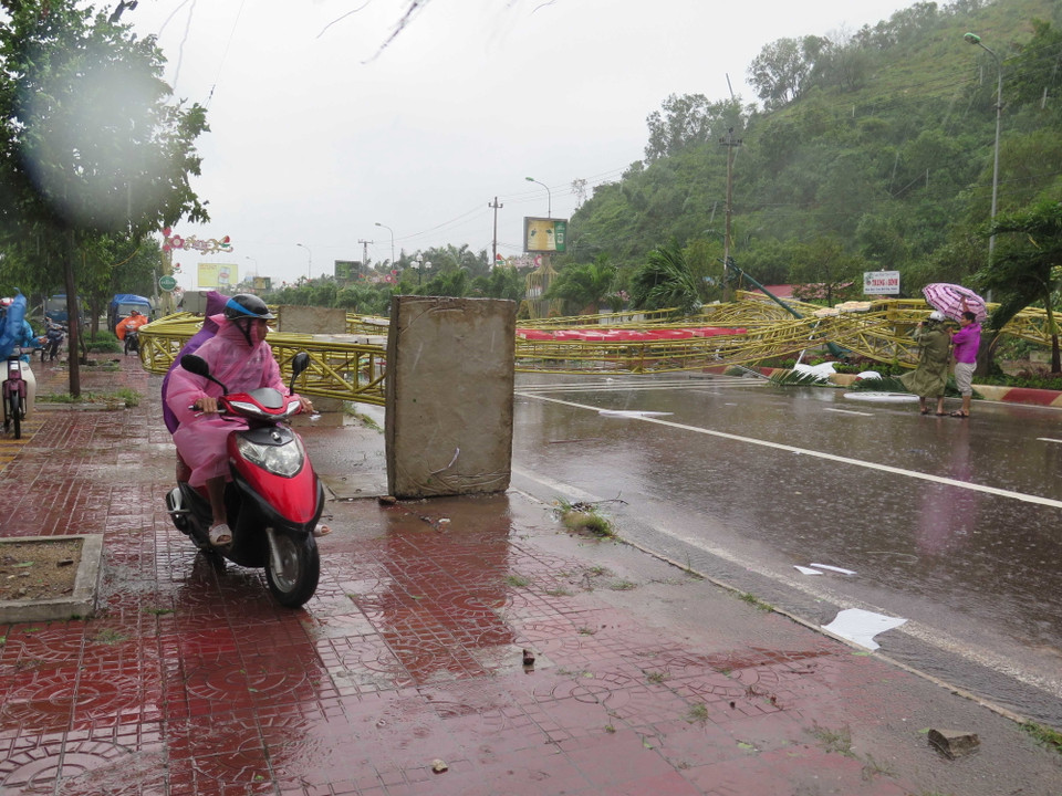 Cổng chào mỹ thuật bằng sắt không có trụ móng bị đổ chắn ngang đầu đường Nguyễn Tất Thành, thành phố Quy Nhơn. (Ảnh: Phạm Kha/TTXVN)