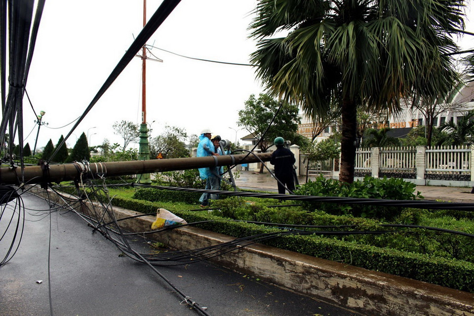 Công nhân điện lực Phú Yên khẩn trương khôi phục lại mạng lưới điện 22 KV ở thành phố Tuy Hòa bị ngã đổ. (Ảnh: Thế Lập/TTXVN)