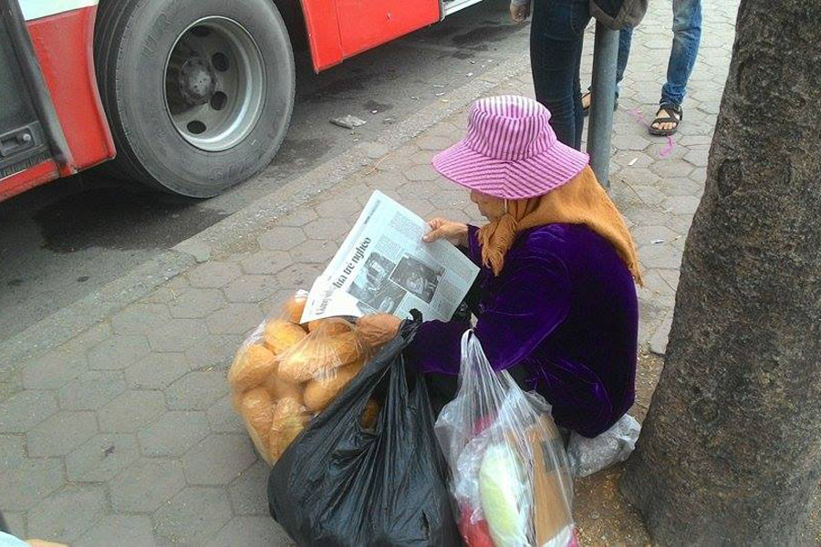 Đại diện Ngày Nay cho biết tờ tạp chí này đã có kế hoạch phát miễn phí trong 5 năm. Ảnh: Tranh thủ đọc báo lúc rảnh rỗi, chờ việc ở bến xe Giáp Bát. (Nguồn: CTV/Vietnam+)