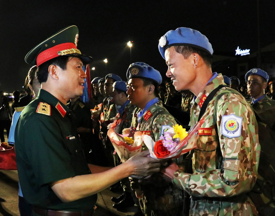 Trung tướng Nguyễn Tân Cương, Phó Tổng tham mưu trưởng Quân đội nhân dân Việt Nam (trái) tặng hoa chúc mừng các cán bộ, chiến sỹ Bệnh viện dã chiến cấp 2 số 1 trở về nước trong đợt này. (Ảnh: Xuân Khu/TTXVN)