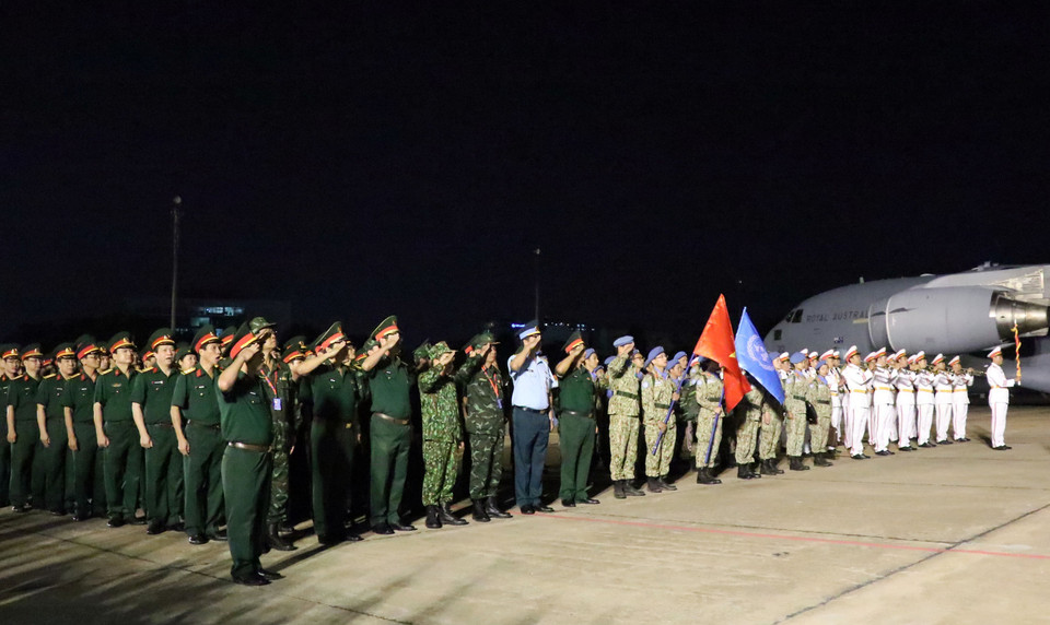 Nhóm đầu tiên gồm 31 cán bộ, chiến sỹ của Bệnh viện dã chiến cấp 2 số 1 thực hiện nghi lễ chào cờ Tổ quốc ngay sau khi xuống máy bay. (Ảnh: Xuân Khu/TTXVN)