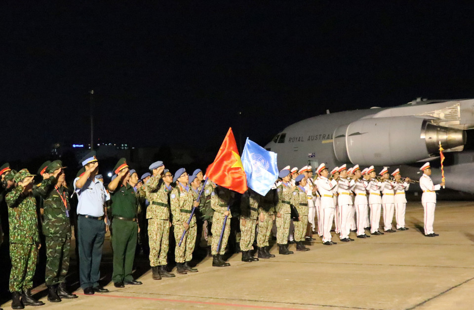 Nhóm đầu tiên gồm 31 cán bộ, chiến sỹ của Bệnh viện dã chiến cấp 2 số 1 thực hiện nghi lễ chào cờ Tổ quốc ngay sau khi xuống máy bay. (Ảnh: Xuân Khu/TTXVN)