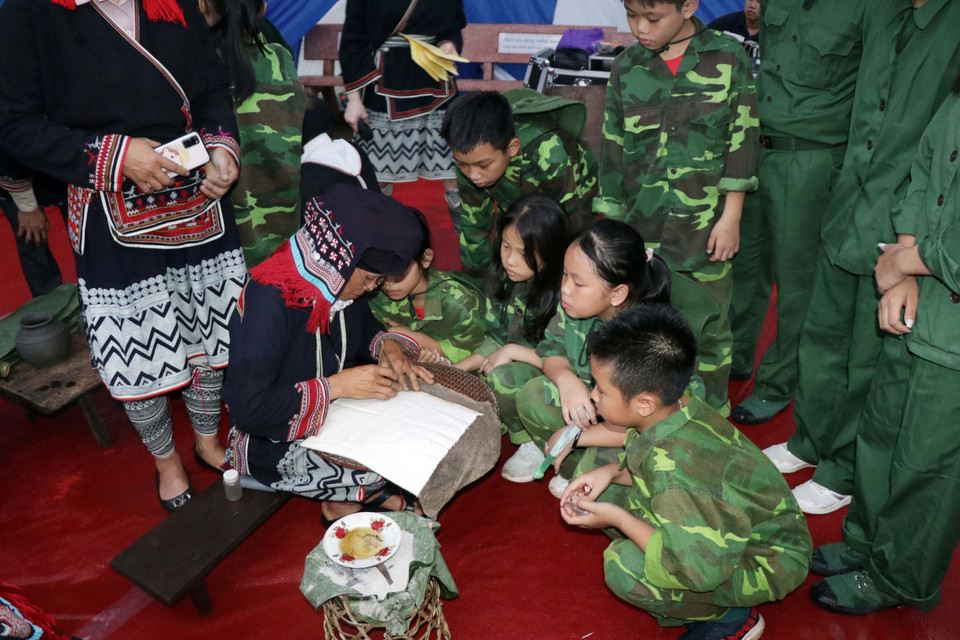 Hoạt động trình diễn các nét văn hóa của người Dao thu hút đông đảo các em nhỏ tìm hiểu. (Ảnh: Hữu Quyết/TTXVN)