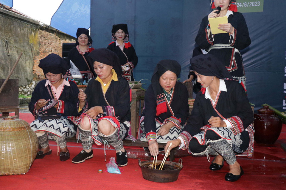 Các nghệ nhân người Dao trình diễn trang trí hoa văn trên vải và nhuộm vải. (Ảnh: Hữu Quyết/TTXVN)