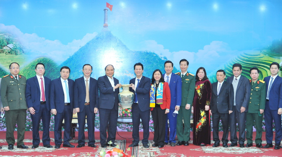 Chủ tịch nước Nguyễn Xuân Phúc đón nhận quà kỷ niệm do đồng chí Đặng Quốc Khánh, Ủy viên Ban chấp hành Trung ương Đảng, Bí thư tỉnh ủy Hà Giang trao tặng. (Ảnh: Minh Đức/TTXVN)