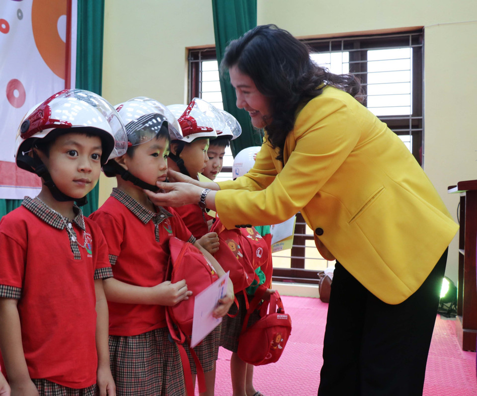 Trao tặng mũ bảo hiểm cho học sinh trường Mầm non Giang Sơn, xã Giang Sơn, huyện Gia Bình, tỉnh Bắc Ninh. (Ảnh: TTXVN)