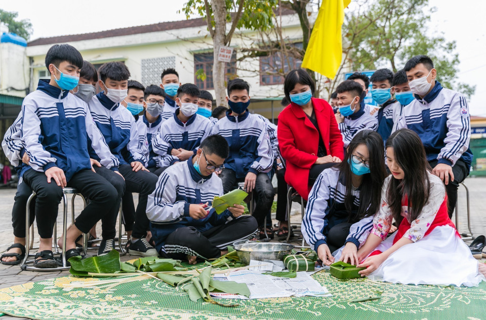Học sinh trường THPT Nguyễn Trường Tộ tự tay trải nghiệm hoạt động gói bánh chưng trong chương trình Tết cổ truyền dân tộc tại Nghệ An. (Ảnh: Bích Huệ/TTXVN)