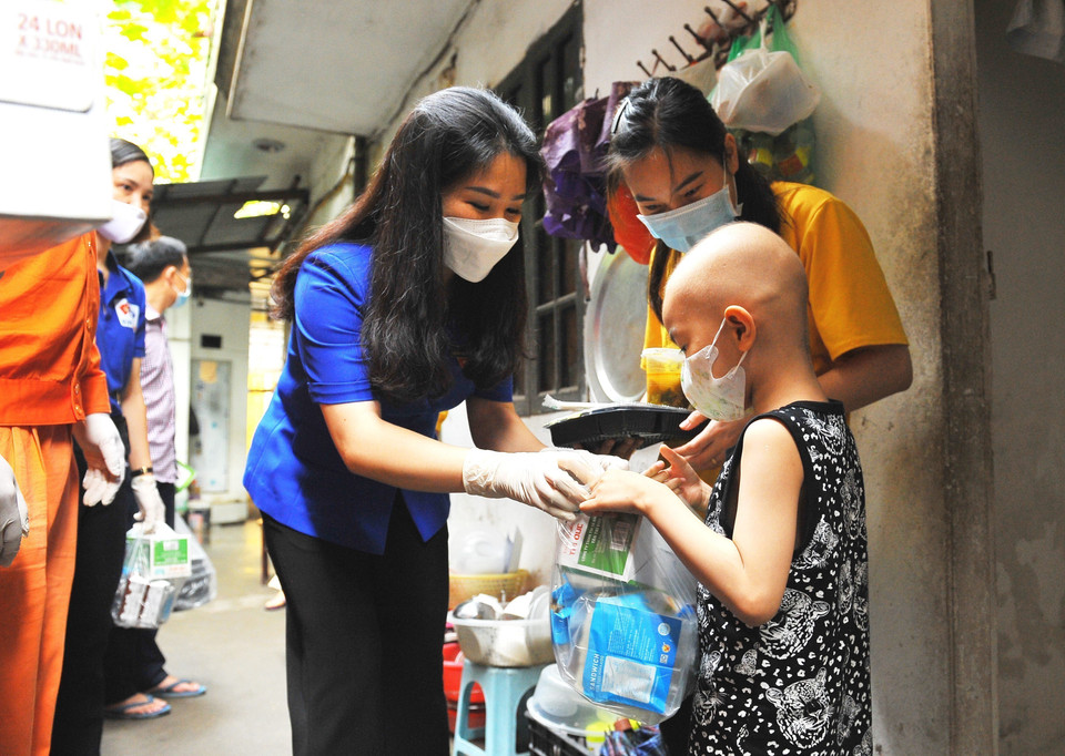 Bí thư Thành đoàn Hà Nội Chu Hồng Minh trao tặng các suất cơm nghĩa tình cho người nhà bệnh nhân đang điều trị tại Bệnh viện Nhi ở ngõ 897 Đường Đê La Thành. (Ảnh: Minh Đức/TTXVN)