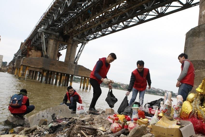 Sinh viên tình nguyện vệ sinh bảo vệ môi trường trong dịp Tết Ông Công, Ông Táo (23 tháng Chạp) tại khu vực sông Hồng. (Ảnh: Anh Tuấn/TTXVN)