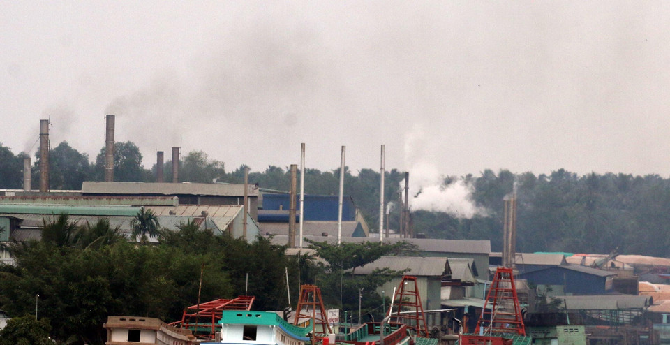 Các ống khói thải mù mịt ra từ các nhà máy bột cá nằm dọc sông Cái Bé, tỉnh Kiên Giang, gây ô nhiễm môi trường không khí. (Ảnh: Lê Sen/TTXVN)