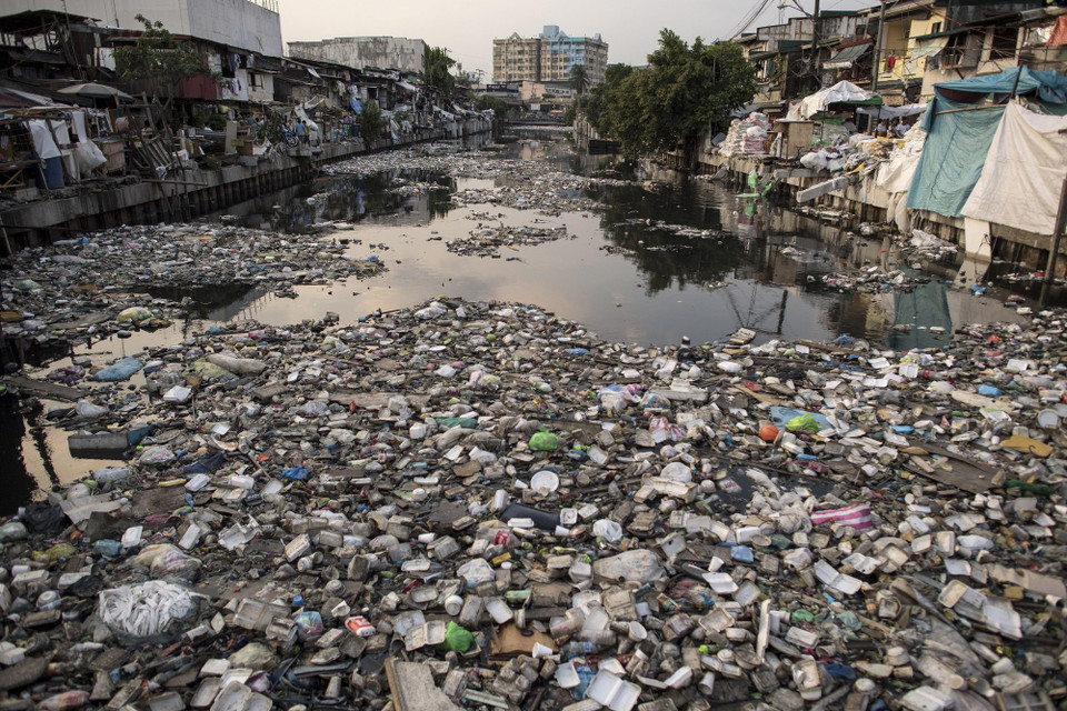 Philippines đã sử dụng một lượng khổng lồ các túi nilon dùng một lần khi mỗi ngày có tới gần 48 triệu túi nhựa dùng để mua hàng được sử dụng trên khắp Philippines, tương đương với 60 tỷ túi bao bì nhựa/năm. Trong ảnh: Rác thải trên một con kênh ở Manila. (Ảnh: AFP/TTXVN phát)