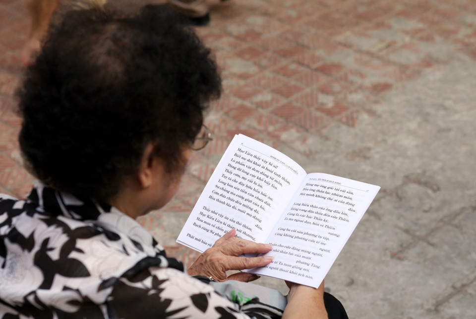 Nhiều cụ già có mặt từ rất sớm, ngồi đọc sách kinh Vu Lan và báo hiếu.(Doãn Đức/Vietnam+)