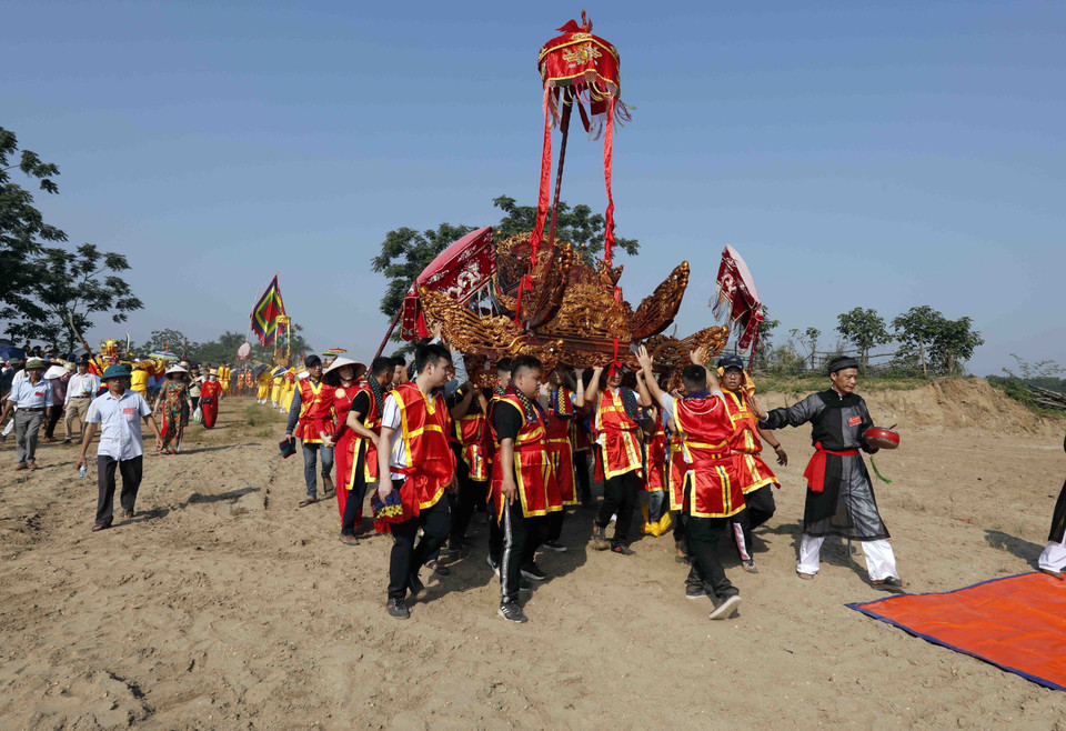 Những cỗ kiệu được rước ra bãi cát, nơi tương truyền Chử Đồng Tử và Tiên Dung Công chúa gặp nhau. (Ảnh: Trấn Việt/TTXVN)