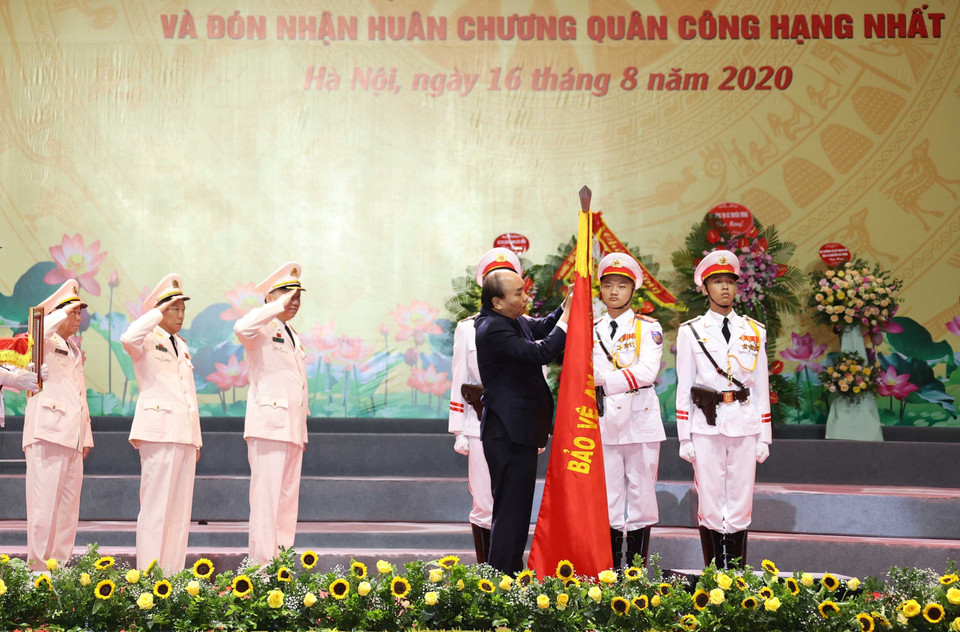 Thủ tướng Nguyễn Xuân Phúc gắn Huân chương Quân công hạng Nhất trên cờ truyền thống của lực lượng Công an nhân dân. (Ảnh: Thống Nhất/TTXVN)