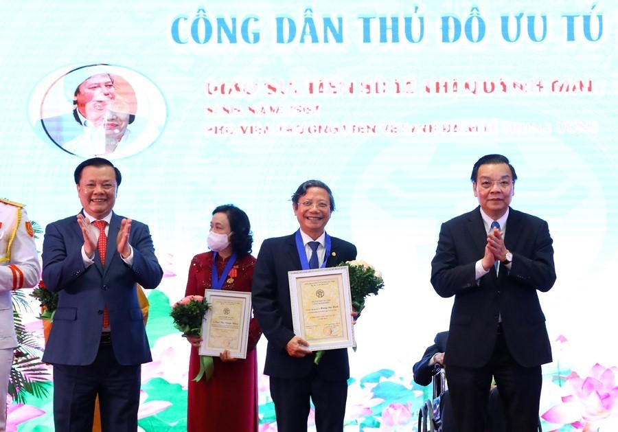 Bí thư Thành ủy Hà Nội Đinh Tiến Dũng và Chủ tịch UBND thành phố Hà Nội Chu Ngọc Anh trao tặng danh hiệu “Công dân Thủ đô ưu tú” năm 2021 cho PGS.TS. Thầy thuốc nhân dân Hoàng Đức Hạnh, nguyên Phó Giám đốc Sở Y tế Hà Nội. (Ảnh: Nguyễn Điệp/TTXVN)