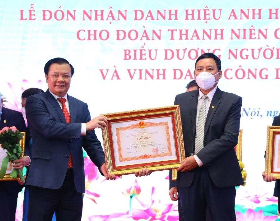  Đồng chí Đinh Tiến Dũng, Ủy viên Bộ Chính trị, Bí thư Thành ủy Hà Nội trao Bằng khen của Thủ tướng Chính phủ tặng cho các tập thể, cá nhân có thành tích xuất sắc trong công tác phòng, chống dịch COVID-19. (Ảnh: Nguyễn Điệp/TTXVN)