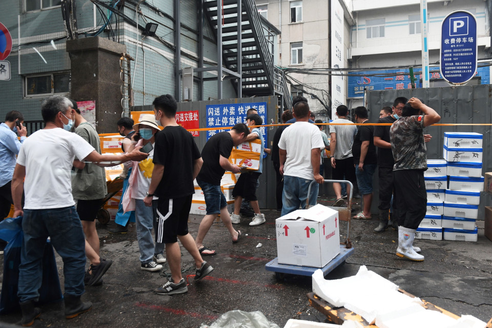 Người dân chuyển hàng hóa khỏi chợ Tân Phát Địa ở Bắc Kinh, Trung Quốc, ngày 13/6, sau khi chợ phải đóng cửa để khử trùng do phát hiện các ca nhiễm COVID-19 mới. (Ảnh: AFP/TTXVN)