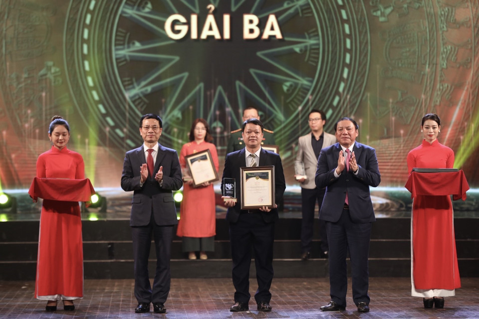  Bộ trưởng Bộ Thông tin và Truyền thông Nguyễn Mạnh Hùng và Bộ trưởng Bộ Văn hóa, Thể thao và Du lịch Nguyễn Văn Hùng trao giải Ba cho các tác giả, nhóm tác giả đoạt giải. (Ảnh: Minh Quyết/TTXVN)