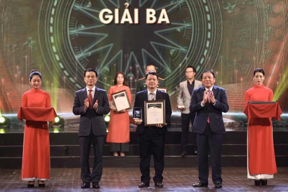  Bộ trưởng Bộ Thông tin và Truyền thông Nguyễn Mạnh Hùng và Bộ trưởng Bộ Văn hóa, Thể thao và Du lịch Nguyễn Văn Hùng trao giải Ba cho các tác giả, nhóm tác giả đoạt giải. (Ảnh: Minh Quyết/TTXVN)