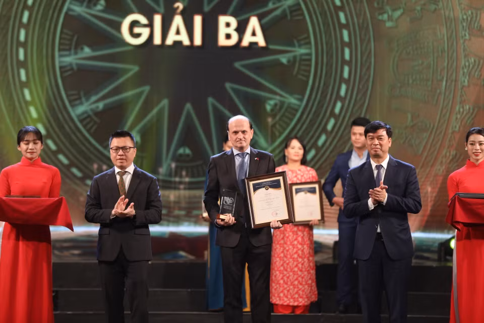 Ông Lê Quốc Minh, Tổng biên tập Báo Nhân dân và ông Ngô Minh Hiển, Phó Tổng giám đốc VOV trao giải Ba cho các tác giả, nhóm tác giả đoạt giải. (Ảnh: Minh Quyết/TTXVN)